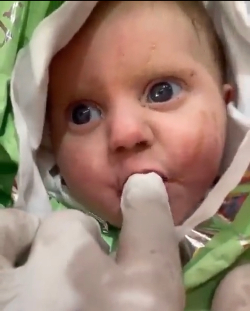 寶寶獲救后肉緊狂啜救援人員的手指，看來非常肚餓。 網(wǎng)上圖片