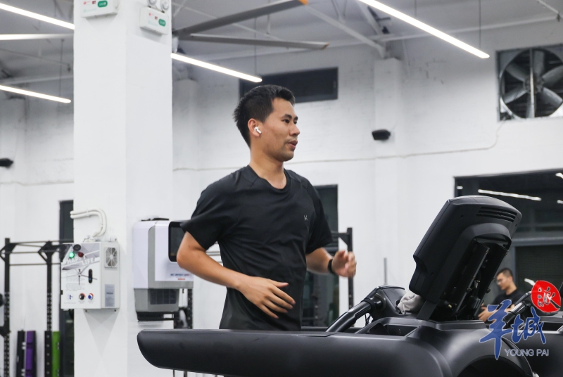 健身者戴上耳機，沉浸在跑步的世界里