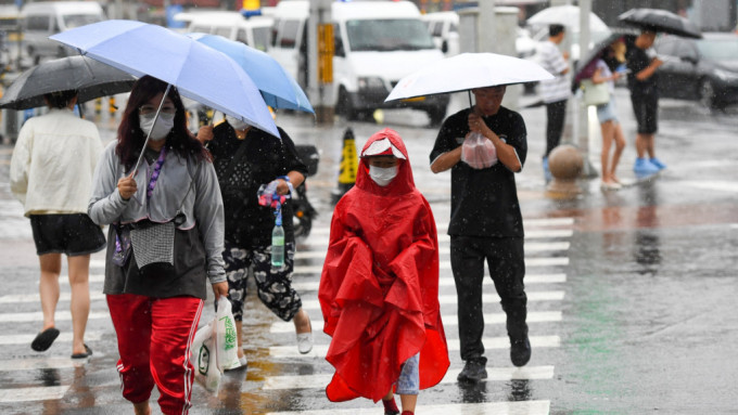 在北京市朝陽區(qū)行人冒雨行走在路上 在北京市朝陽區(qū)行人冒雨行走在路上