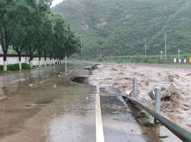 北京暴雨，多區(qū)出現(xiàn)水浸，河道旁的道路亦被沖毀。