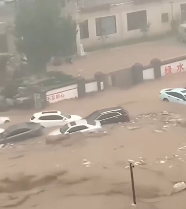 北京暴雨困，門頭溝大量汽車被沖走。