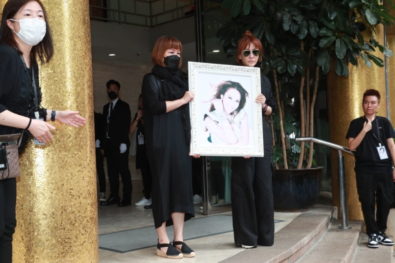 兩位姐姐手捧妹妹的遺照 兩位姐姐手捧妹妹的遺照