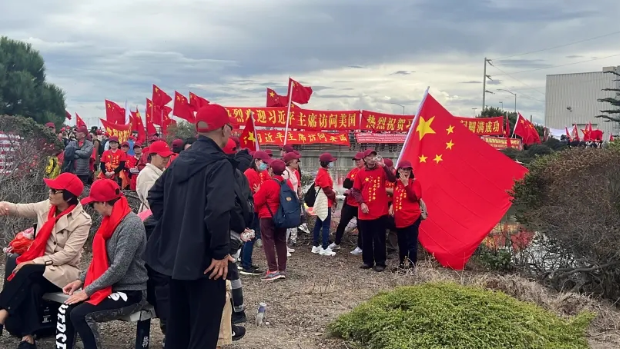 大批僑胞在舊金山國際機(jī)場外的海傍揮舞五星紅旗，準(zhǔn)備歡送習(xí)近平主席。