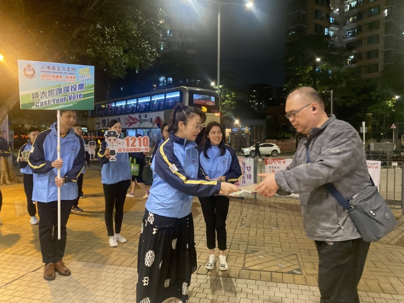 入境處助理處長(zhǎng)（個(gè)人證件）楊素英（左）向市民派發(fā)傳單，宣傳區(qū)議會(huì)選舉。