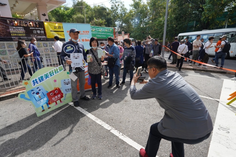 票站外也有介紹區(qū)議會選舉的「打卡位」，不少已投票的市民拍照。
