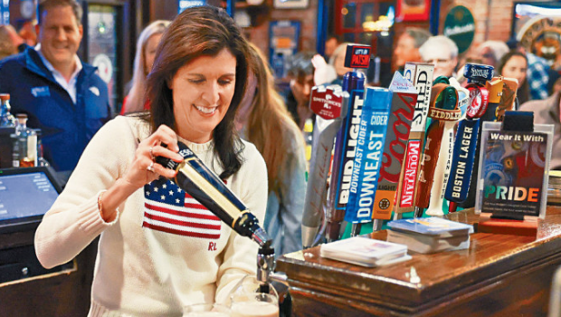 黑利上周六在新罕布什爾州一間酒吧拉票時(shí)，倒啤酒入酒杯。