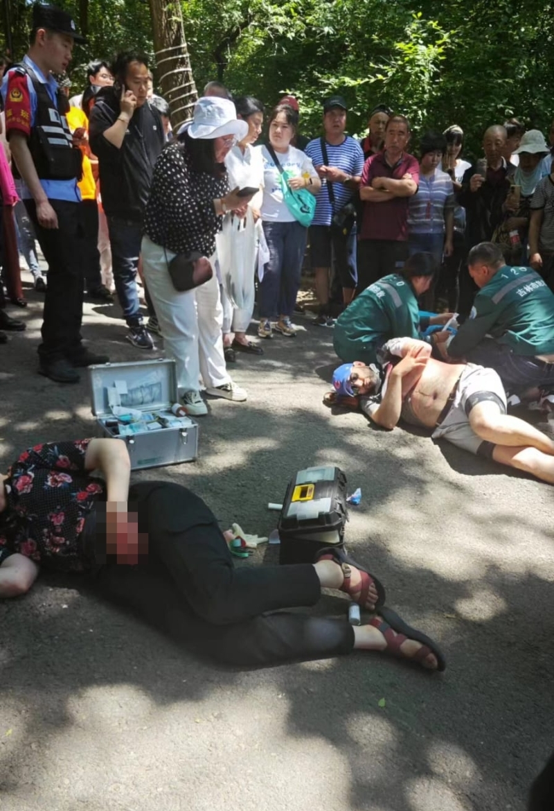 兩名疑是外國(guó)人躺在地上，救護(hù)人員到場(chǎng)處理。
