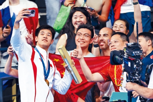 潘展樂在巴黎100米自由泳奪金后同觀眾合影。