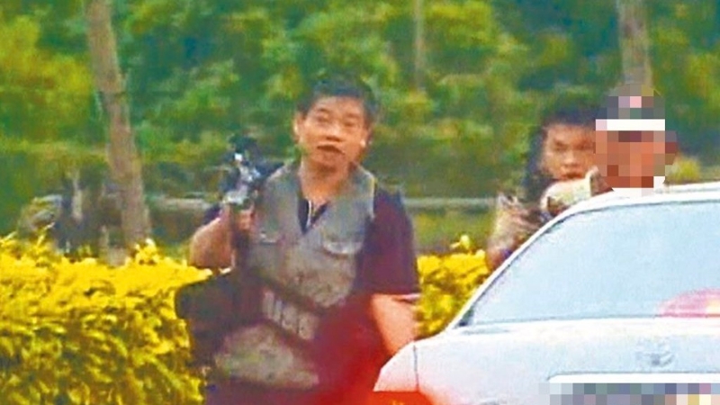 “臺灣張子強(qiáng)”張錫銘（左一）2004年與同伙被圍捕時挾持1名老農(nóng)（右一）和警察街頭槍戰(zhàn)。