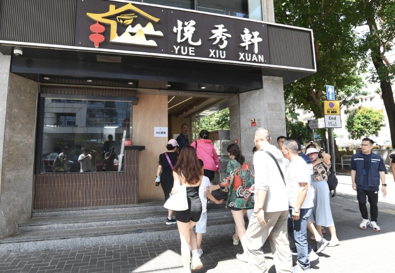 團(tuán)友們落車后在導(dǎo)游領(lǐng)隊(duì)指揮下急急腳步入餐廳。 何君健攝