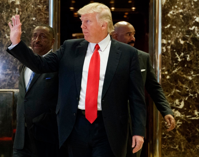 美國準(zhǔn)總統(tǒng)特朗普迅速公布內(nèi)閣名單，圖為他步出紐約特朗普大樓金碧輝煌的電梯，向在場人士揮手的資料照。