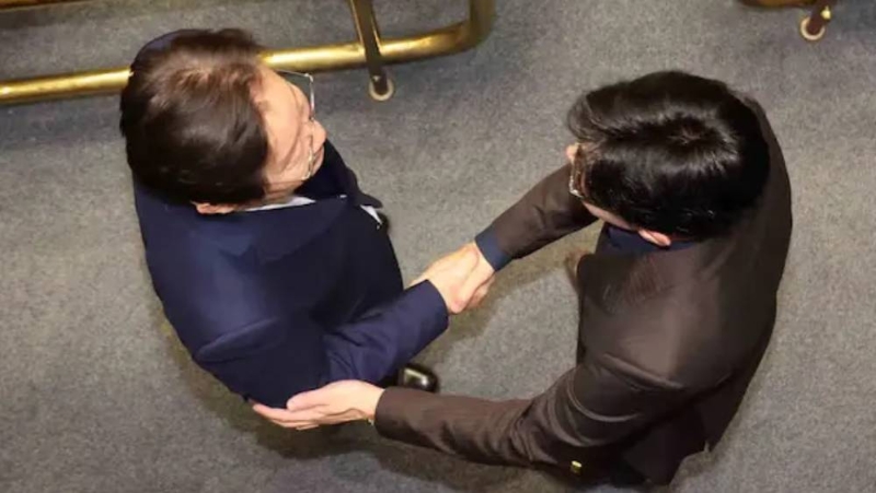 南韓國(guó)會(huì)投票解除戒嚴(yán)后，韓國(guó)朝野兩大政黨黨魁在現(xiàn)場(chǎng)握手。 李在明（左）、韓東勛（右）。 中國(guó)新聞網(wǎng)截圖
