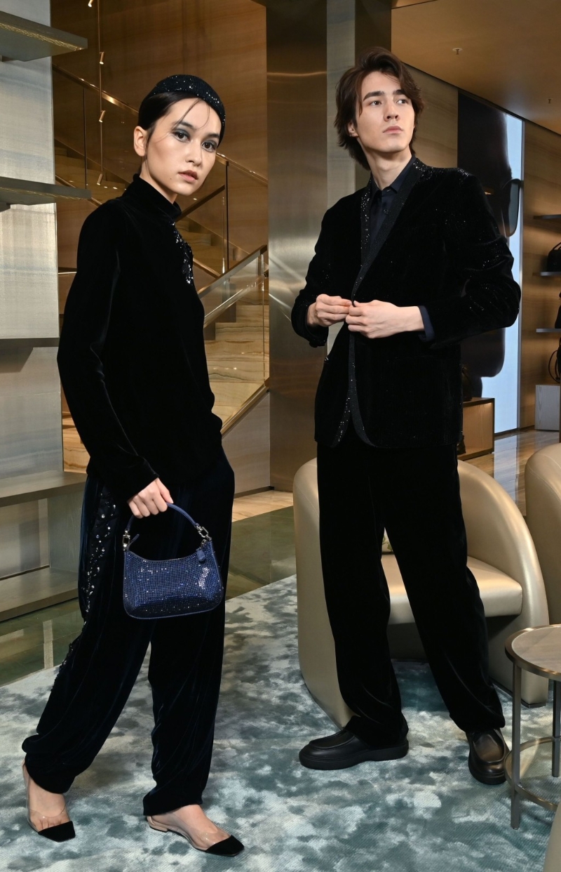 On Miya：閃石刺繡帽、黑色絲絨蜻蜓刺繡圖案上衣、黑色絲絨蜻蜓刺繡圖案長(zhǎng)褲、綺面迷你水鉆LA PRIMA手提包、裸色拼黑色尖頭平底鞋。 On Aslan：?jiǎn)闻趴坶W亮天鵝絨燕尾服外套、深藍(lán)色真絲襯衫、天鵝絨平角長(zhǎng)褲、黑色皮鞋。