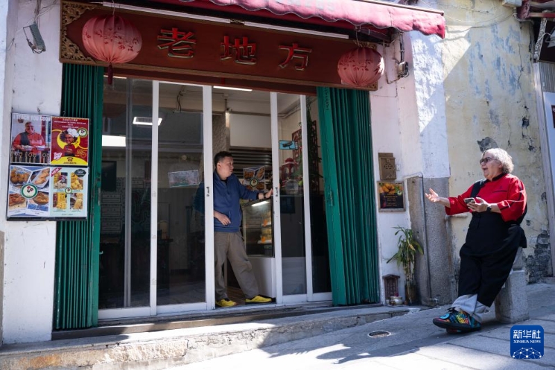 土生葡人馬安娜（右）在“老地方”餐廳門口與同事聊天