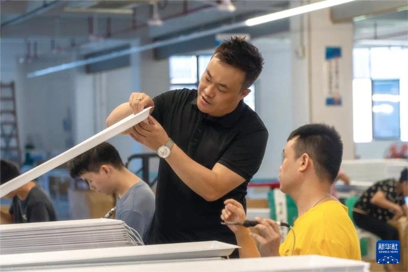 工業(yè)設(shè)計師馬馳（左）和同事在工作室中研究產(chǎn)品