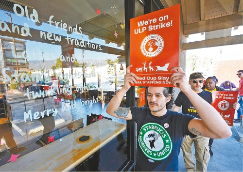 圖為加州洛杉磯伯班克的星巴克員工，20日在一間已關(guān)門的星巴克外舉行罷工抗議。 美聯(lián)社