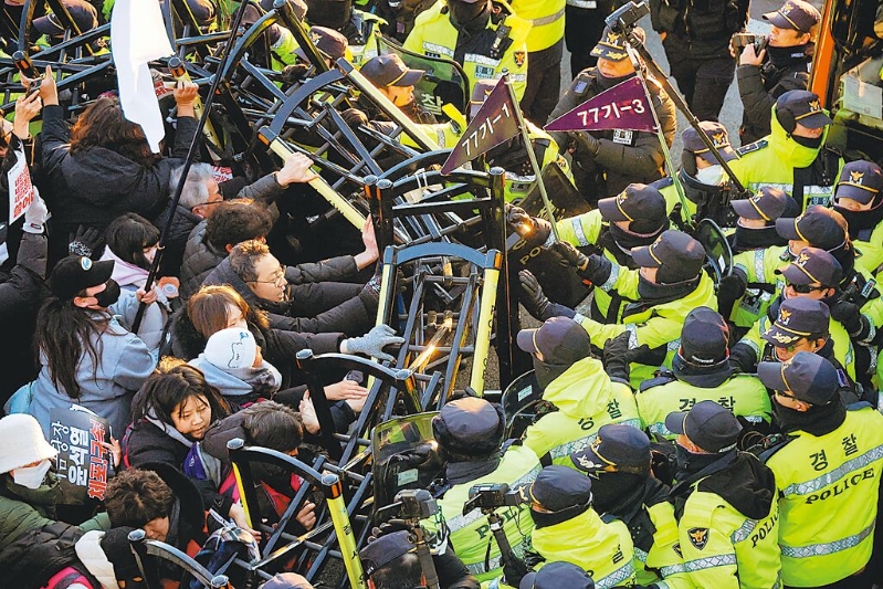 韓國公調(diào)處人員周五與總統(tǒng)警衛(wèi)處經(jīng)過5個(gè)多小時(shí)對(duì)峙，仍無法逮捕被彈劾的總統(tǒng)尹錫悅。圖為反尹的抗議民眾，在總統(tǒng)官邸附近與警察發(fā)生沖突。
