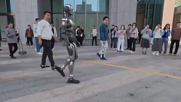 路人駐足圍觀(guān)機(jī)械人。