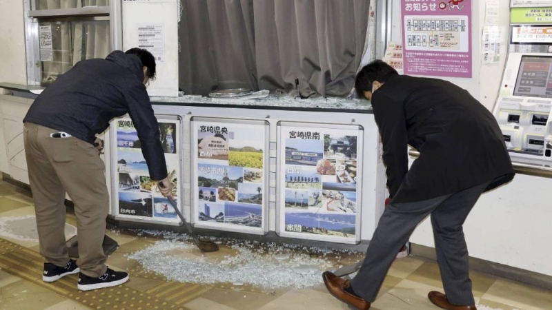 地震發(fā)生后，民眾清理地面碎玻璃。