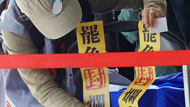 圖為罷免團體工作人員在載運資料的推車上貼著罷免爛委的封條