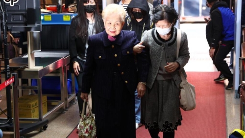 臺(tái)北地院20日針對(duì)京華城案開庭，提訊前臺(tái)北市長(zhǎng)柯文哲等4人?？挛恼芷拮雨惻彗鳎ㄓ遥⒛赣H何瑞英（左）抵達(dá)北院領(lǐng)完旁聽證后，回家休息，在開庭前返回北院旁聽。