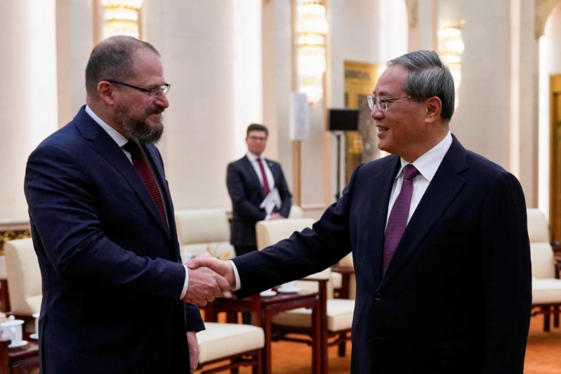 李強(qiáng)和高通公司執(zhí)行長(zhǎng) Cristiano Amonq握手?！⌒氯A社