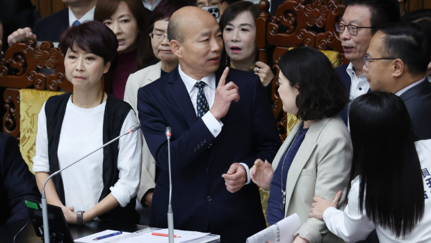 “立法院”25日院會(huì)開(kāi)始，民進(jìn)黨“立委”上到主席臺(tái)包圍院長(zhǎng)韓國(guó)瑜（中）杯葛議事，并要求說(shuō)明新黨副秘書長(zhǎng)游智彬事件，韓宣布休息。