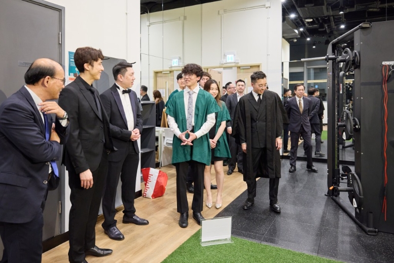 學(xué)生向嘉賓介紹健身室設(shè)施。