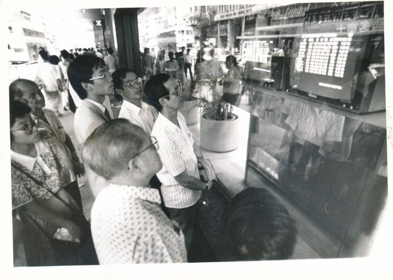 1987年股市瘋狂暴瀉下，商業(yè)區(qū)的股價(jià)傳真吸引大批股民圍觀市況。資料圖片