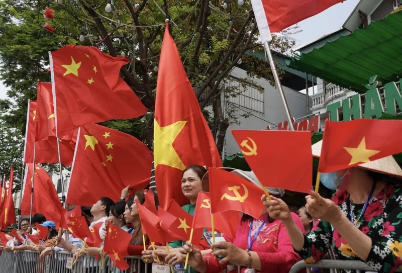 機(jī)場附近有民眾持中越國旗和中共黨旗歡迎習(xí)近平到訪。 新華社