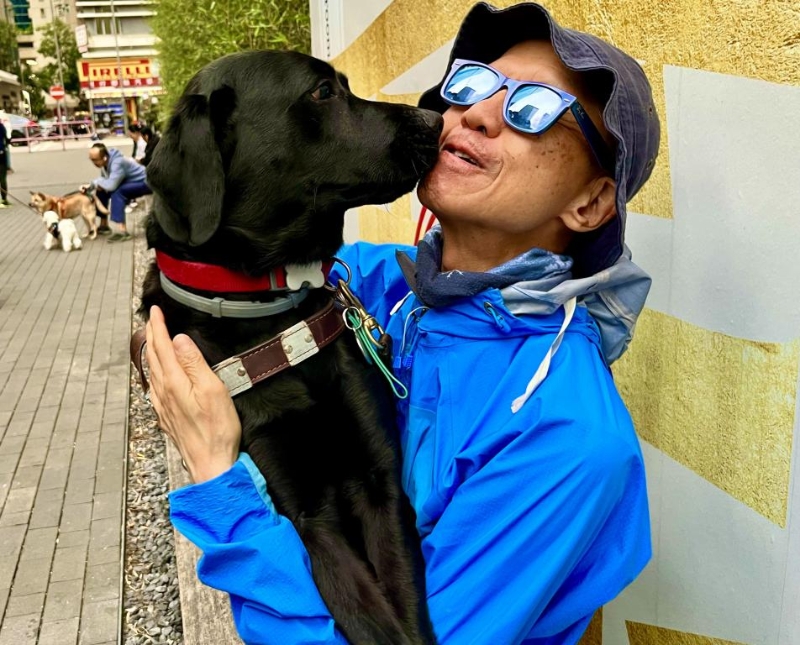 曾建平現(xiàn)由導(dǎo)盲犬Vinny引路。