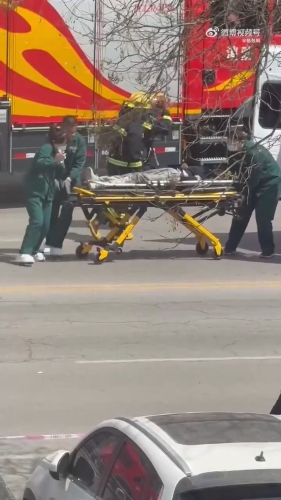 救護(hù)人員將傷者抬上救護(hù)車。