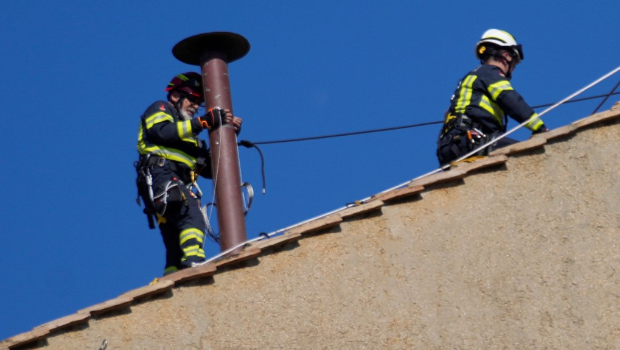 工人爬上西斯汀小圣堂（Sistine Chapel）屋頂安裝煙囪。
