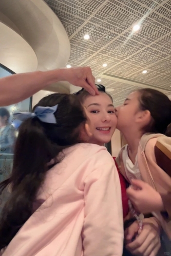 兩名女兒一齊錫方媛面珠，郭富城就以手代嘴親老婆額頭。