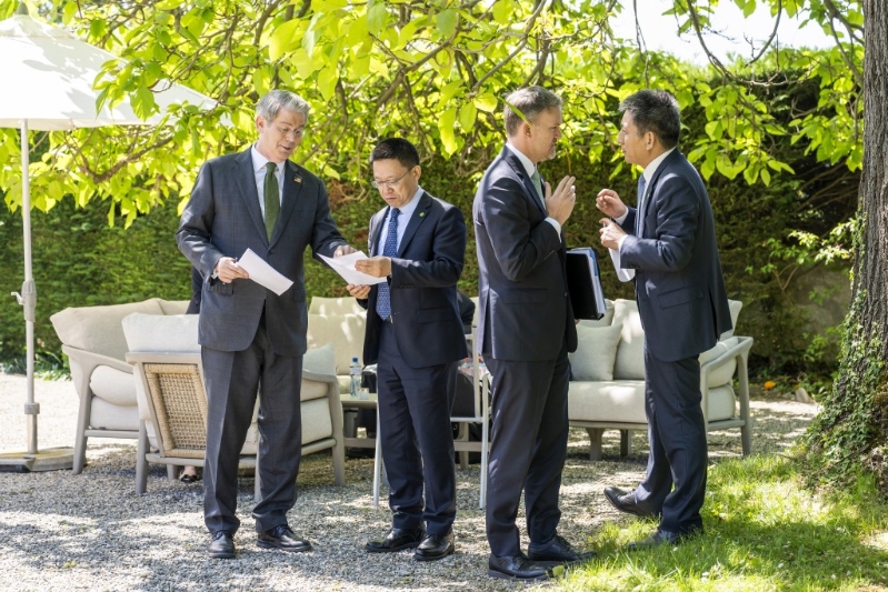 雙方代表團在戶外交談。