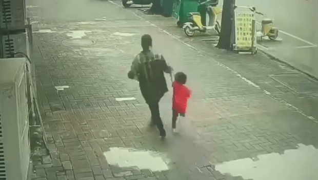 一名女子強行拖走一名小孩。