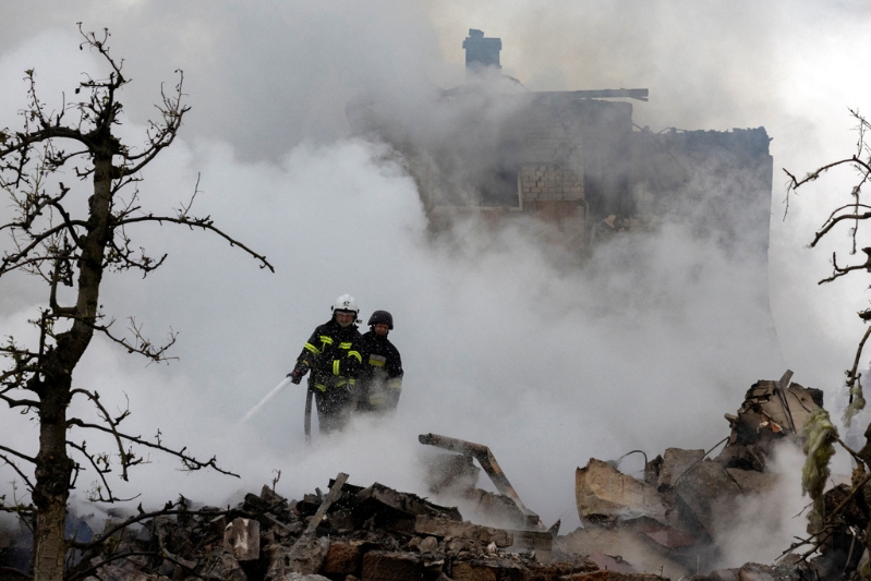 2025年5月25日，俄羅斯空襲擊中被摧毀的民宅與消防人員正在撲滅火情。路透社