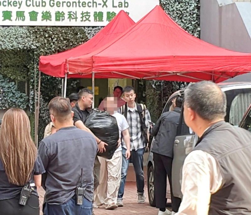 警方6月5日押解其中一名被捕人到宿舍搜證。資料圖片