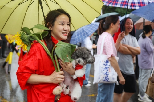 南京的家長帶向日葵送考望“一舉奪魁”。 中新社