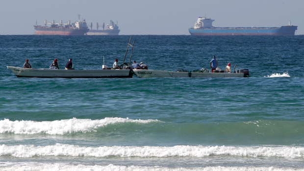 這張攝于2012年1月19日的資料照片中，可見阿拉伯聯(lián)合大公國(guó)拉斯?，敚≧as Al Khaimah）外海、荷姆茲海峽南側(cè)，一排漁船停泊在油輪前方。