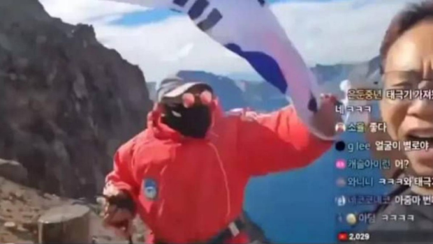 韓國網(wǎng)紅Girit直播在長白山景區(qū)展示韓國國旗及唱國歌。