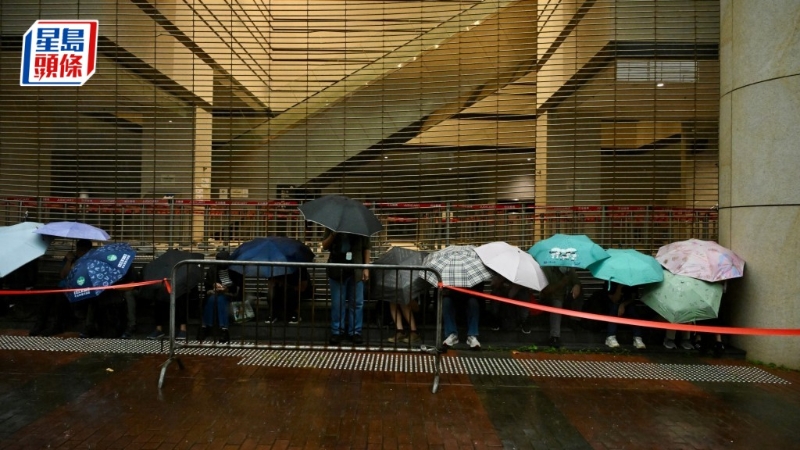 有近百名市民排隊，躲在法院外有瓦遮頭處。