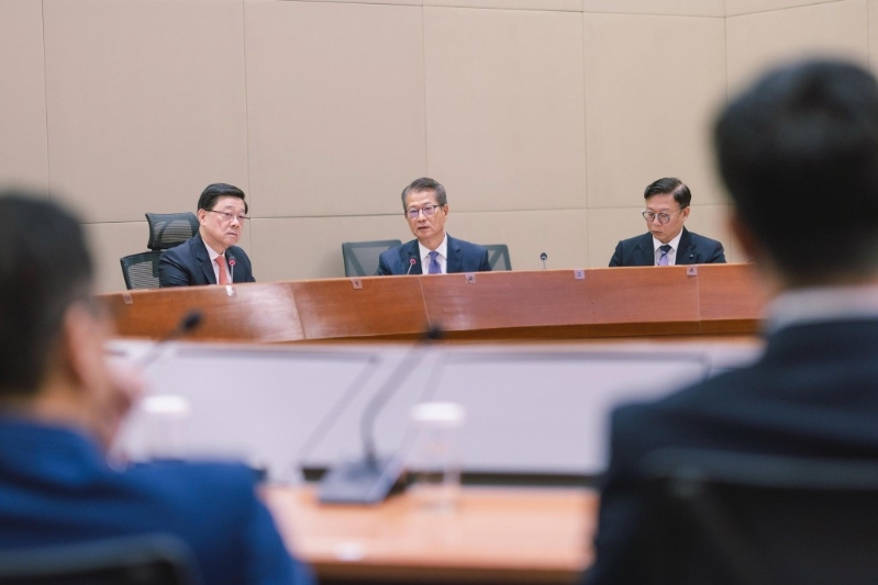 李家超（左）與團隊召開會議學(xué)習(xí)四中全會精神。