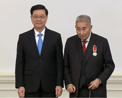 李家超向梁智仁頒發(fā)大紫荊勛章。