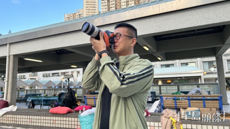 陸先生借用記者長(zhǎng)鏡遙望被燒毀的家園，